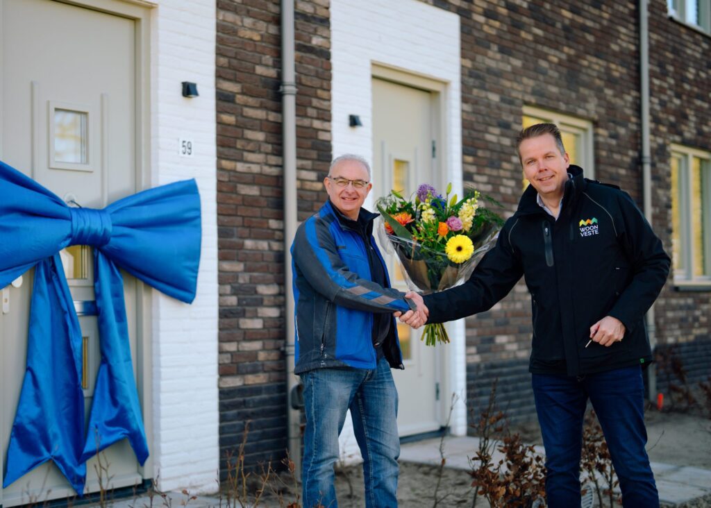 Uitvoerder-Tony-van-Riel-van-Janssen-de-Jong-Bouw-overhandigt-de-sleutel-van-de-laatste-huurwoningen-van-Geerpark-aan-Marcel-van-den-Oever-van-woningcorporatie-Woo-scaled